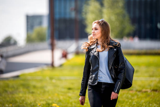 istock Young woman walking with modern buildings in background 1206836104