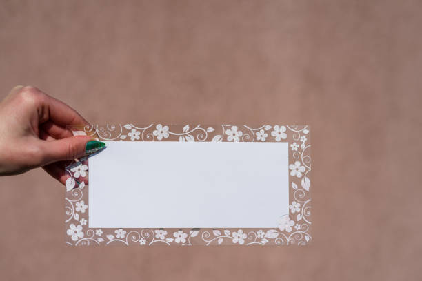 istock Empty space for text with decorated floral frame, greeting card design poster banner or ivitation . hand holding a blank sheet of paper. Rectangular template or layout for certificate diploma flyer  list reminder letter ticket. 1206837187