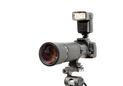 Camera with telephoto lens isolated on white background