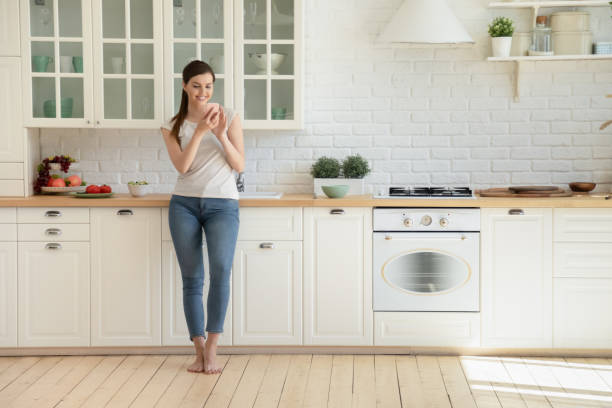 istock Millennial girl using cellphone in modern home kitchen 1206837860