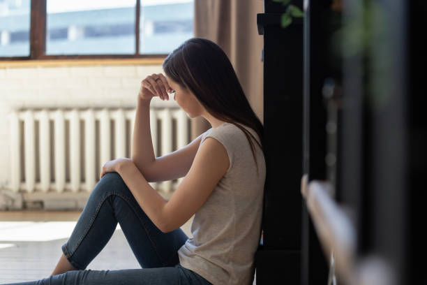 istock Sad young woman sit on floor lost in thoughts suffering 1206837877