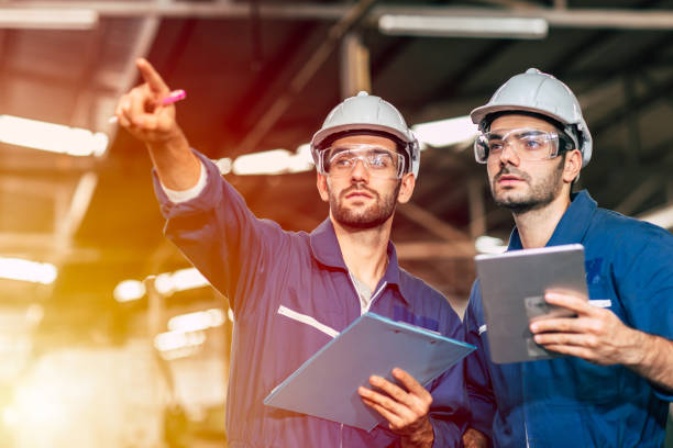 istock Two engineer worker working together with safety uniform and white helmet to work in industry factory handle tablet. 1206839379