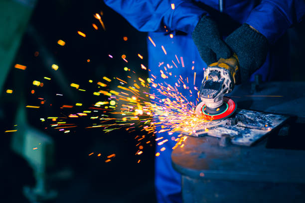 istock Closeup heavy steel worker using electric wheel grinding disc cuting metal plate in workplace danger fire light sparking from tool. 1206840168