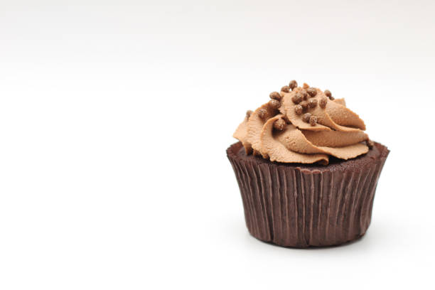 istock Isolated chocolate cupcake with cream top and crispy topping on a white background 1206841385
