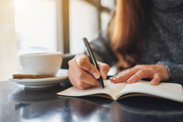 istock a woman writing on a blank notebook on the table 1206843272
