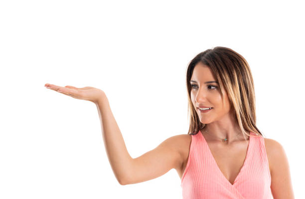 istock Happy young woman in pink top showing empty copyspace 1206844502