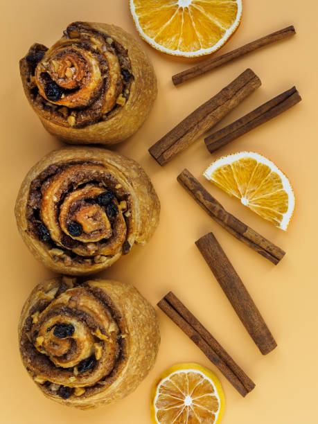 istock Cinnamon, nut and raisin buns and lemon on orange background 1206847398