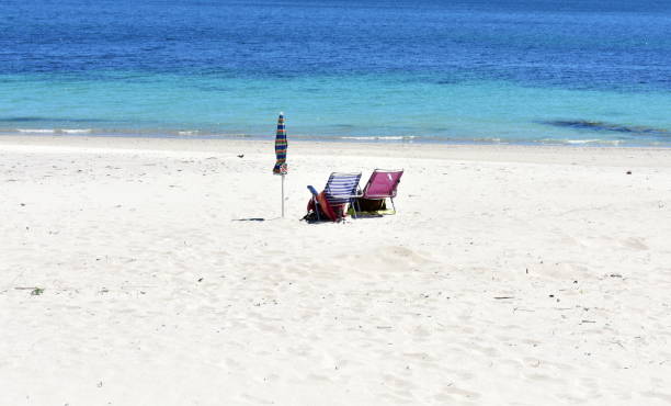 istock Beach chairs and umbrella on a beach with white sand and turquoise water. Spain. 1206848053