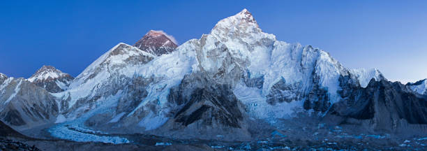 um panorama das montanhas mais altas do mundo - monte everest, nuptse e khumbu queda de gelo durante a hora azul. - kala pattar - fotografias e filmes do acervo