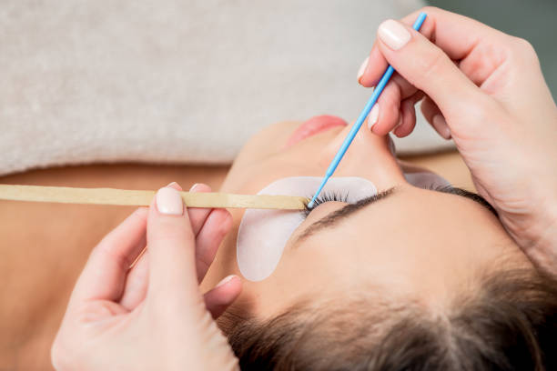 istock Woman receiving eyelash extension procedure. 1206849231