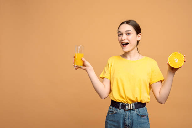 feliz retrato de estilo de vida saudável de mulher esportiva sorridente segurando conjunto de vitaminas com suco de laranja e frutas nas mãos e olhando para a câmera isolada com copyspace - isolated on white fun orange food - fotografias e filmes do acervo