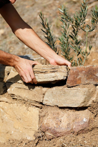 istock Close-up of construction worker builds stone wall 1206852304