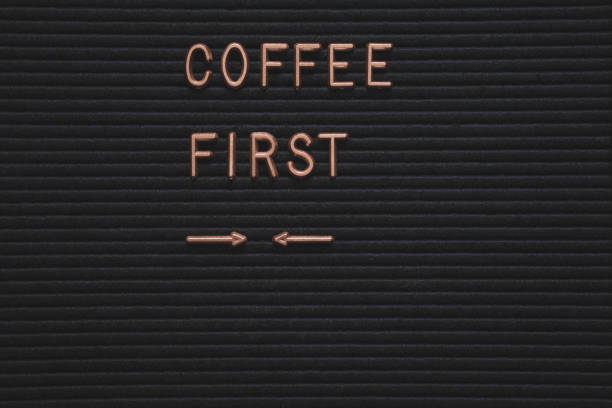 coffee first words on modern board at white background, top view. Overhead, flat lay, from above. Red coffee mug with fresh coffee beans