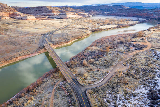 highway across Colorado River with the remain of historic Dewey Bridge above Moab In Utah, aerial view of winter scenery, travel concept