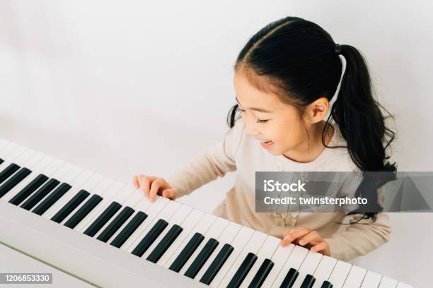 Satisfied Asian Kid Playing Piano At Home Stock Photo - Download Image Now - Piano, Child, Music