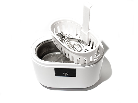Cleaning systems for medical instruments. Ultrasonic cleaner on white background