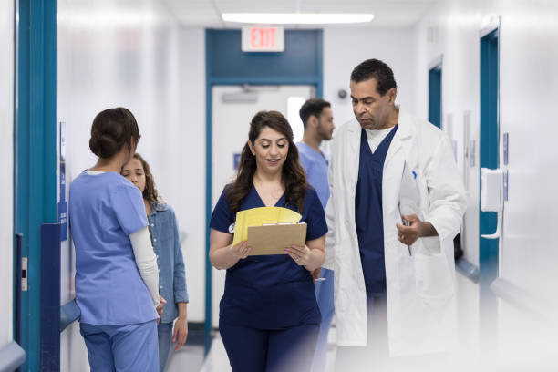 istock While walking in corridor, nursing student asks male doctor questions 1206857176