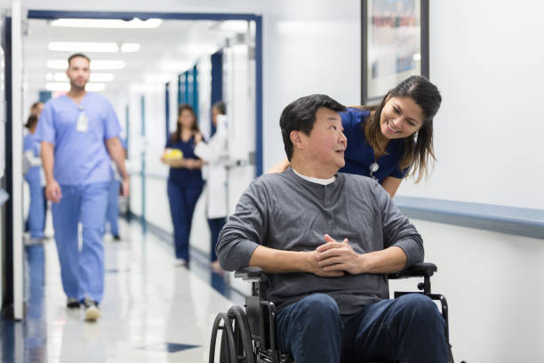 istock Nurse's aid and patient in wheelchair have conversation 1206857196