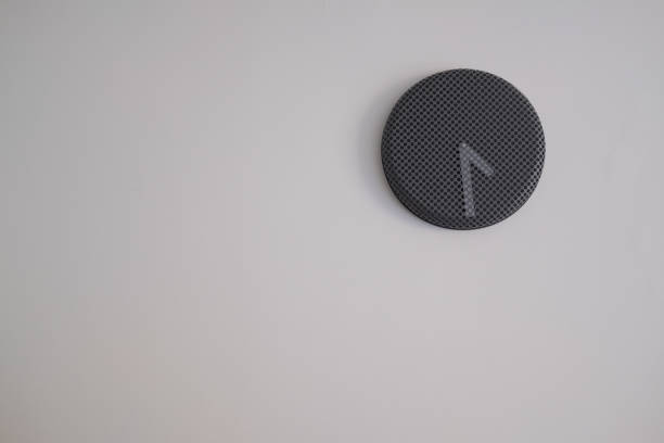 istock Black clock hand hanging on the wall. Minimalist decoration 1206857261