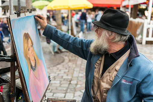 Paris, France - May 21, 2014: Street painter doing portrait works  in Place du Tertre in Montmartre, Paris, France.