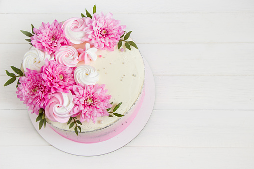 Pink cake. Meringues and pink flowers on the top of cake . Concept for Wedding , St. Valentine's Day, Mother's Day, Birthday Cake. White background