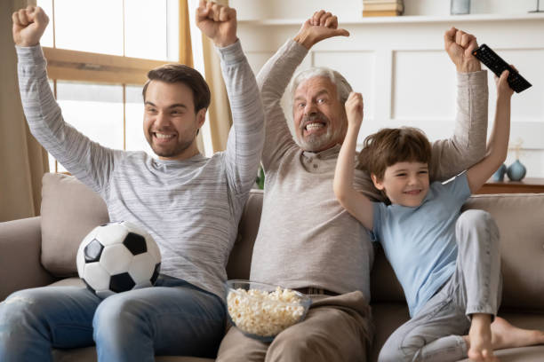 istock Overjoyed three generations male family celebrating championship win. 1206859202