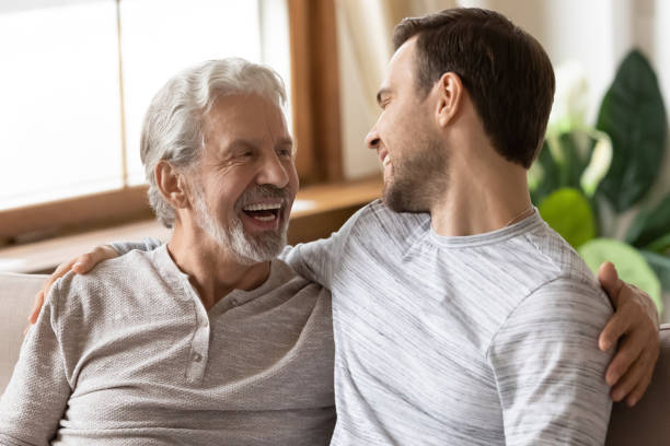 szczęśliwy dojrzały starzec przytulający ramiona dorosłego syna. - senior adult grandfather 70s discussion zdjęcia i obrazy z banku zdjęć