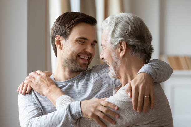 istock Excited middle aged hoary father cuddling grownup son. 1206859759