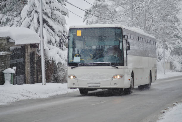 bus blanc sur la rue enneigée - snow car winter road photos et images de collection