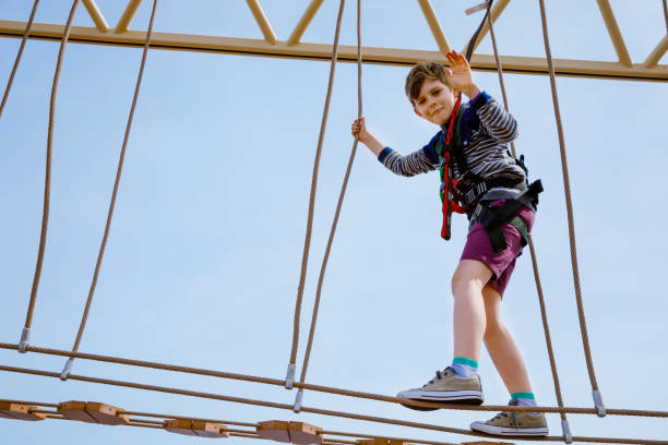 istock Happy little kid boy climbing on high rope course trail. Active child making adventure and action on family vacations. Challenge for brave kids. 1206862006