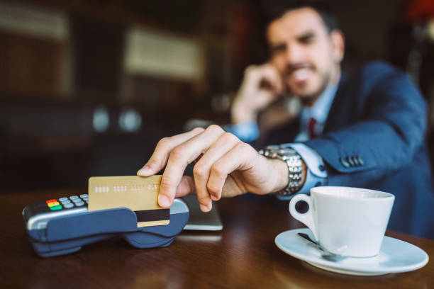 istock Smiling man at coffee break paying with credit card 1206865448