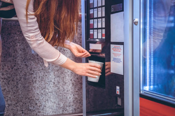 la femme prend le café au distributeur automatique - vending machine photos et images de collection