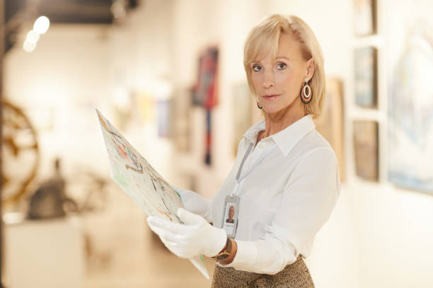istock Mature Art Expert Examining Painting 1206870309