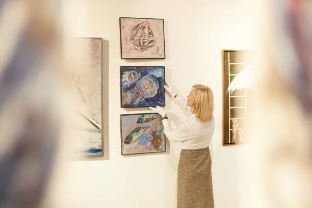 istock Art Gallery Manager Hanging Paintings 1206870314