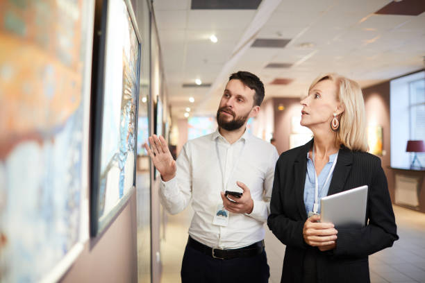 istock Art Experts Looking at Paintings in Museum 1206870330