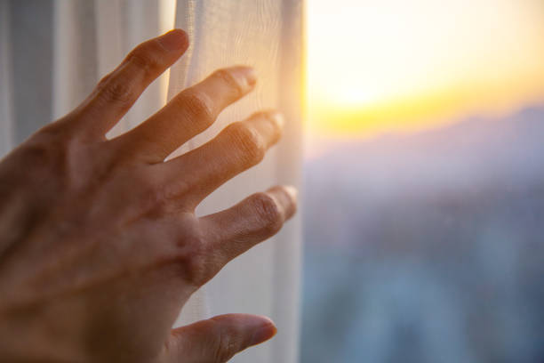 istock Close-up hand open curtan in the morning 1206870852