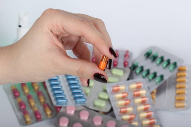 istock pills and tablets handcuffed hands on white background 1206874145