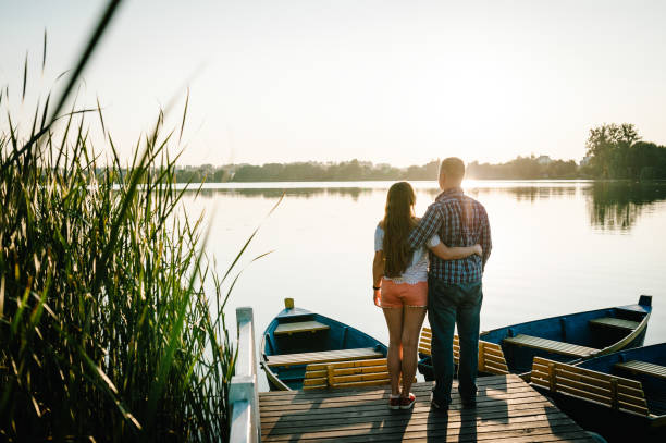 istock Couple hugging and looking in the sunset on pier. Back view. 1206874898