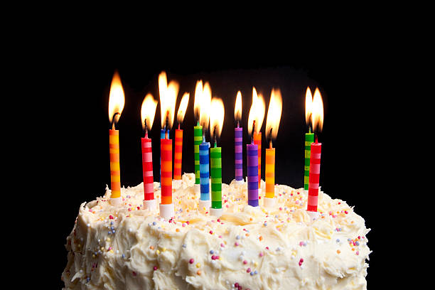 birthday cake and candles on black background stock photo