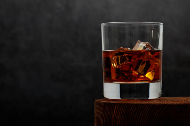 istock Whiskey with ice or brandy in a glass on a rustic background. Whiskey with ice in a glass. Whiskey or brandy. Selective focus. 1206876093