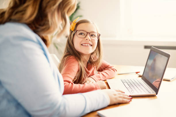 laptop computer education mother children daughter girl familiy childhood Mother and daughter Having fun with laptop at home homework stock pictures, royalty-free photos & images