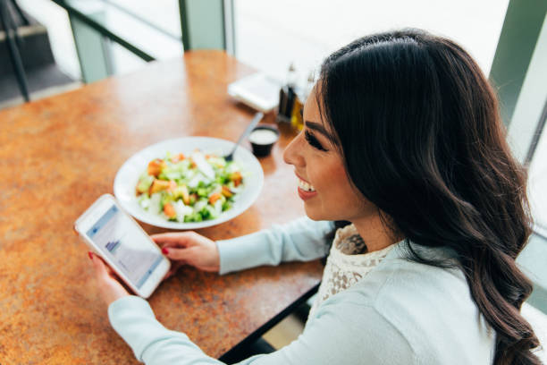 istock Millennial Woman on Phone at Restaurant 1206881928