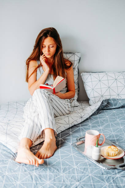 istock Young redhead woman reading in bed. Lazy moring routine. 1206889311