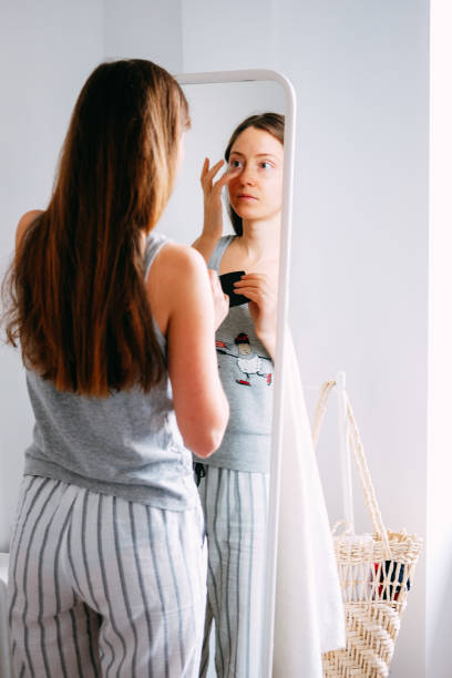 istock Young woman doing her morning routine. Putting on her make up before mirror. 1206889316
