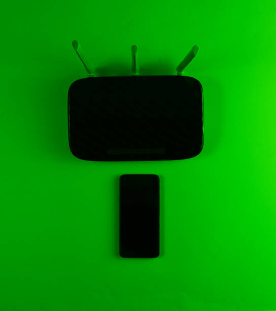 istock Wi fi router, smartphone. Modern gadgets. Green Neon light. Top view 1206891172