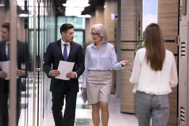 istock Different ages focused international company workers walking in corridor. 1206893434