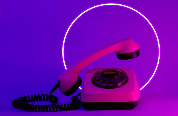 istock Old style rotary telephone with soaring telephone handle. 80's synth wave and retrowave glowing circle futuristic aesthetics. Old fashioned abstraction concept 1206894383