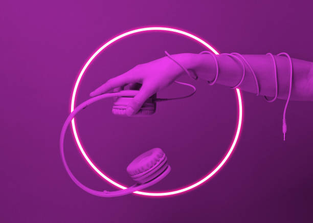 istock Hand wrapped cable holds headphones. 80's synth wave and retrowave glowing circle futuristic aesthetics. Old fashioned abstraction concept 1206894419