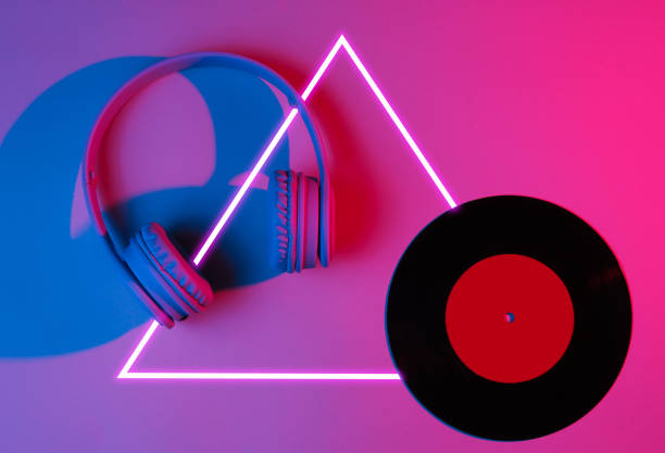 istock Headphones with vinyl record. 80's synth wave and retrowave glowing triangle futuristic aesthetics. Old fashioned abstraction concept 1206894438