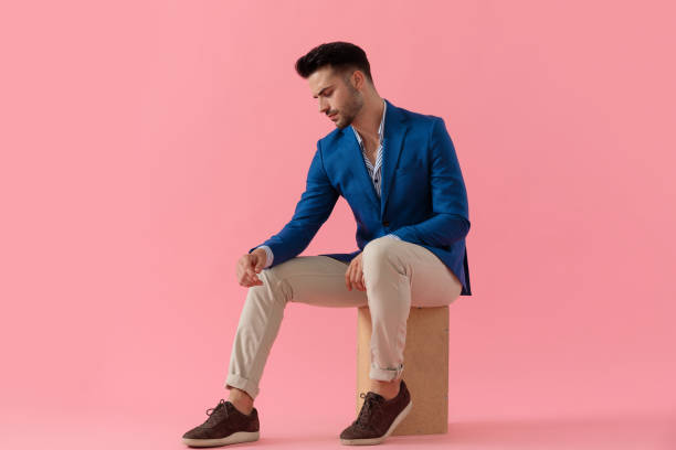 istock young smart casual man holding elbow on knee 1206896848